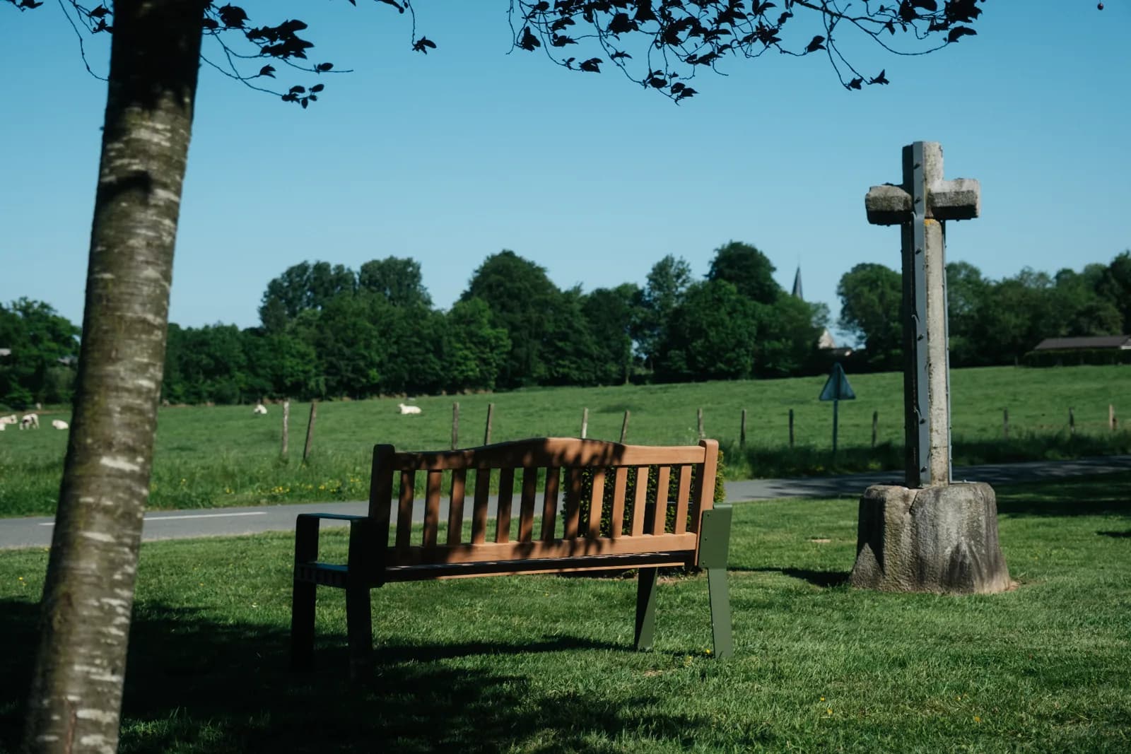 Banc de Mémoire® près d'une croix de pierre en campagne