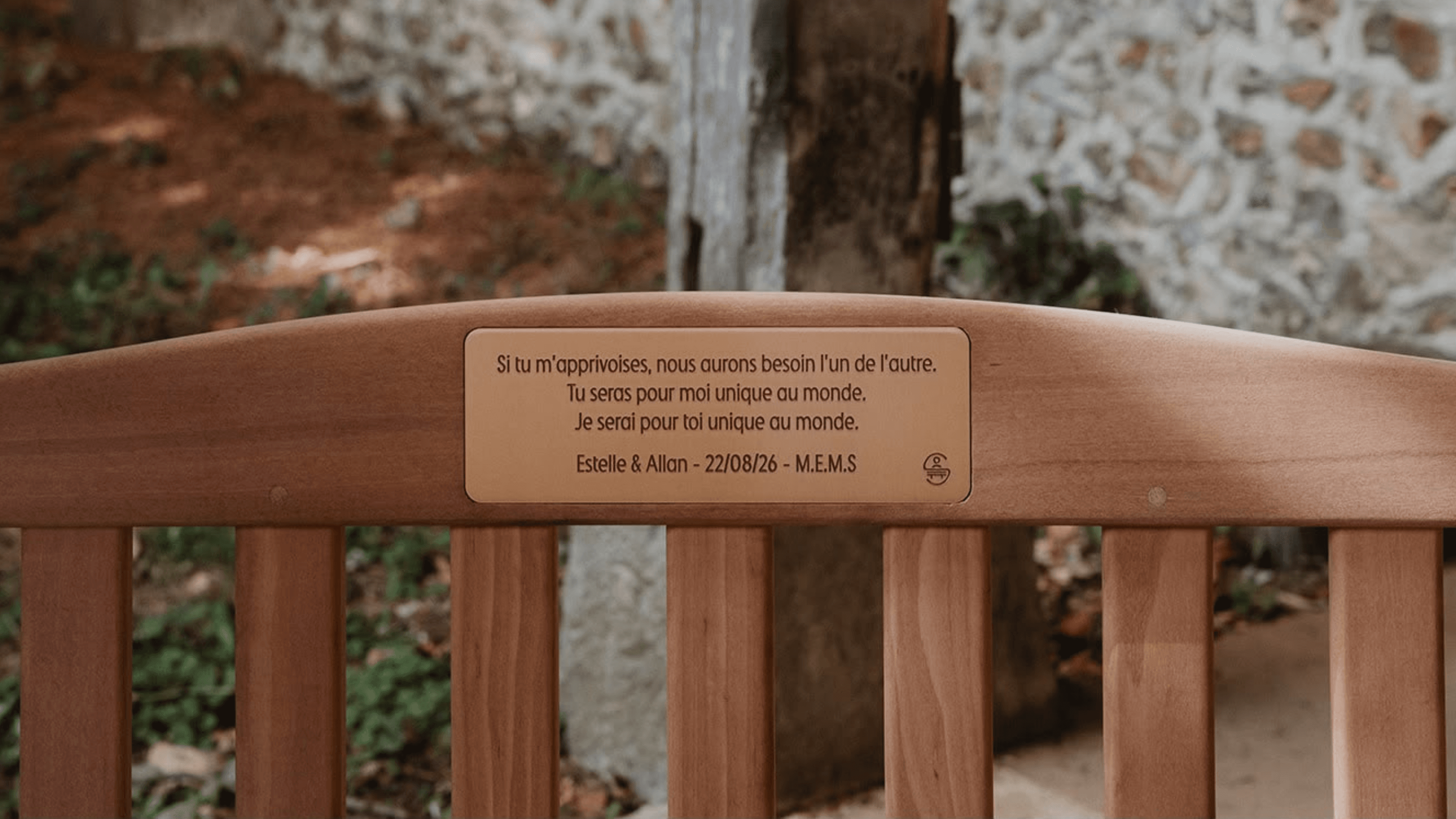 Deux mariés assis sur un banc dans un jardin